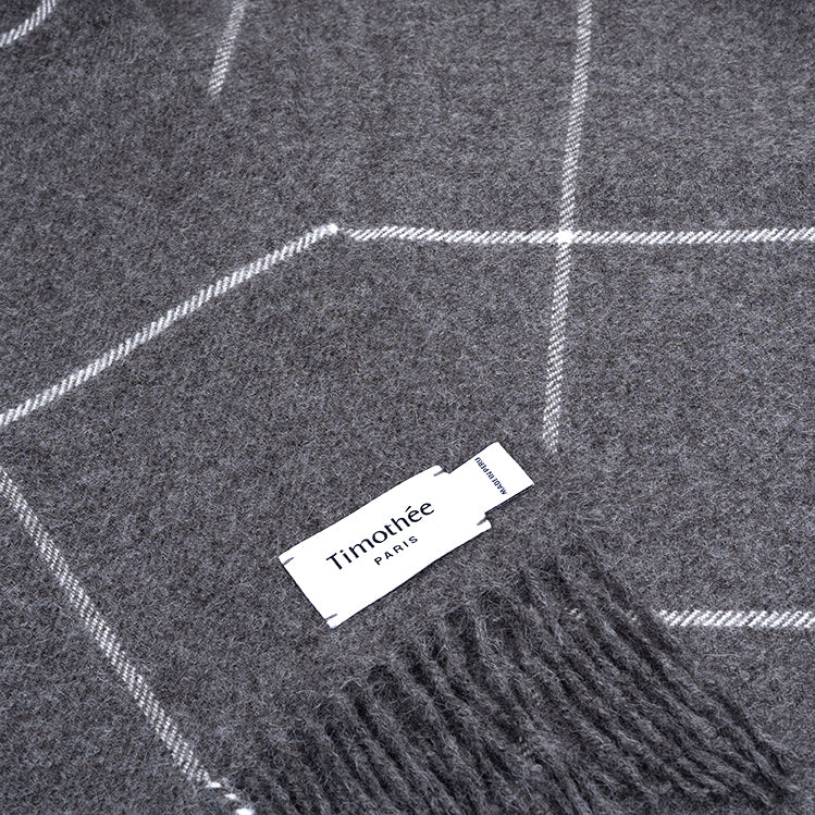 dark grey alpaca blanket by french-lifestyle brand timothee paris close up logo