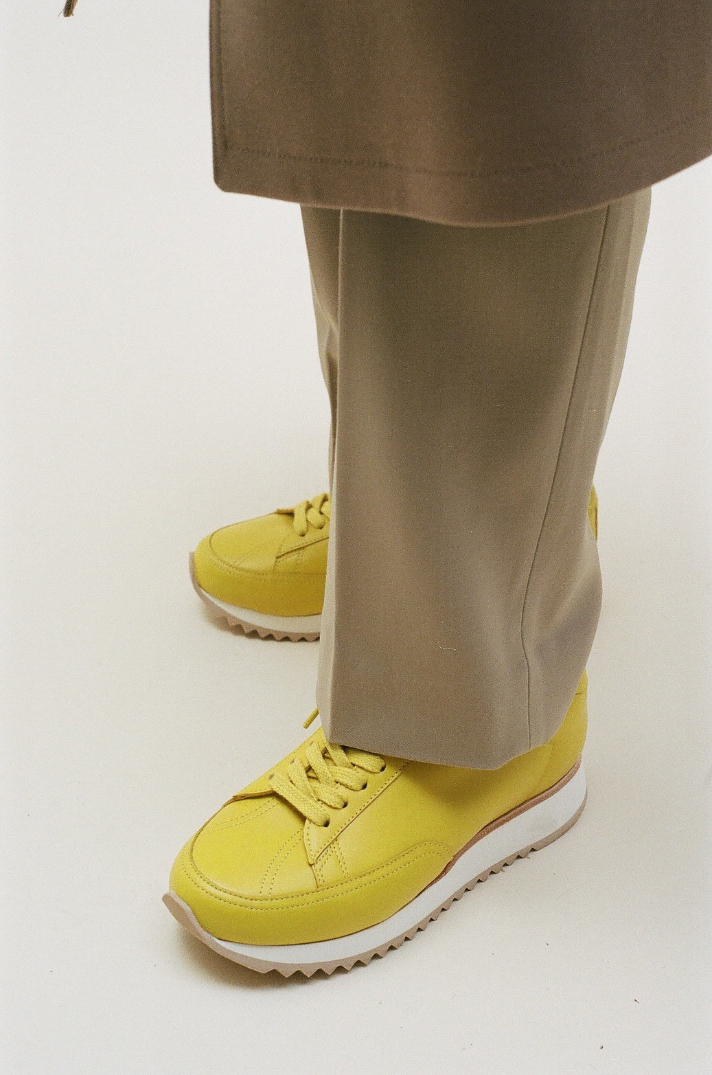 timothee paris cabourg sneaker Yellow women's sneaker with white sole and laces. The shoe features a sleek and modern design with a low profile and rounded toe