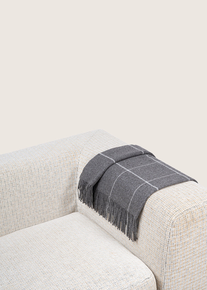 dark grey alpaca blanket by french-lifestyle brand timothee paris on a sofa