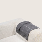 dark grey alpaca blanket by french-lifestyle brand timothee paris on a sofa