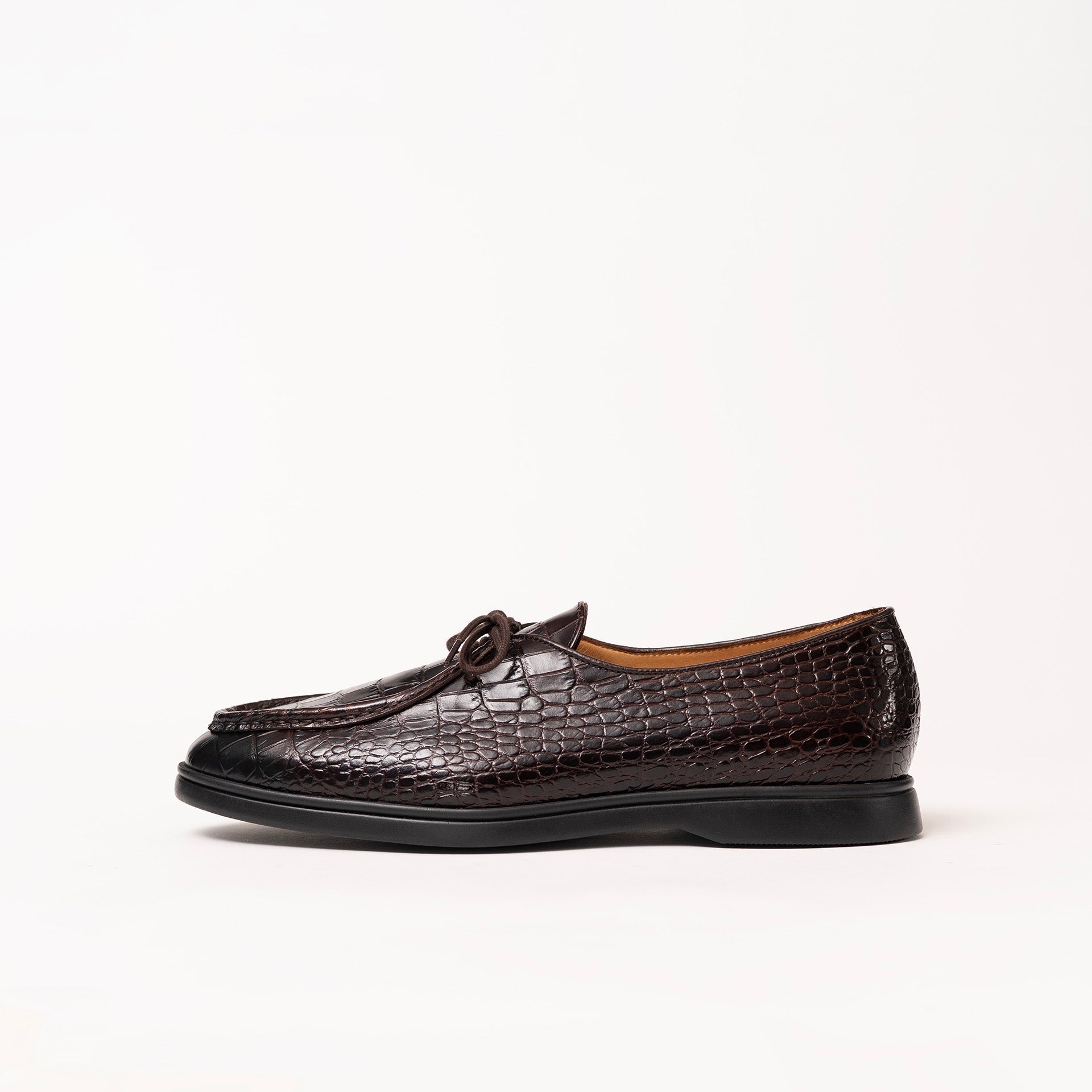 Dark brown crocodile-embossed leather loafer by Timothée Paris with a moccasin-style toe and a low black sole, shown in profile against a plain white background.