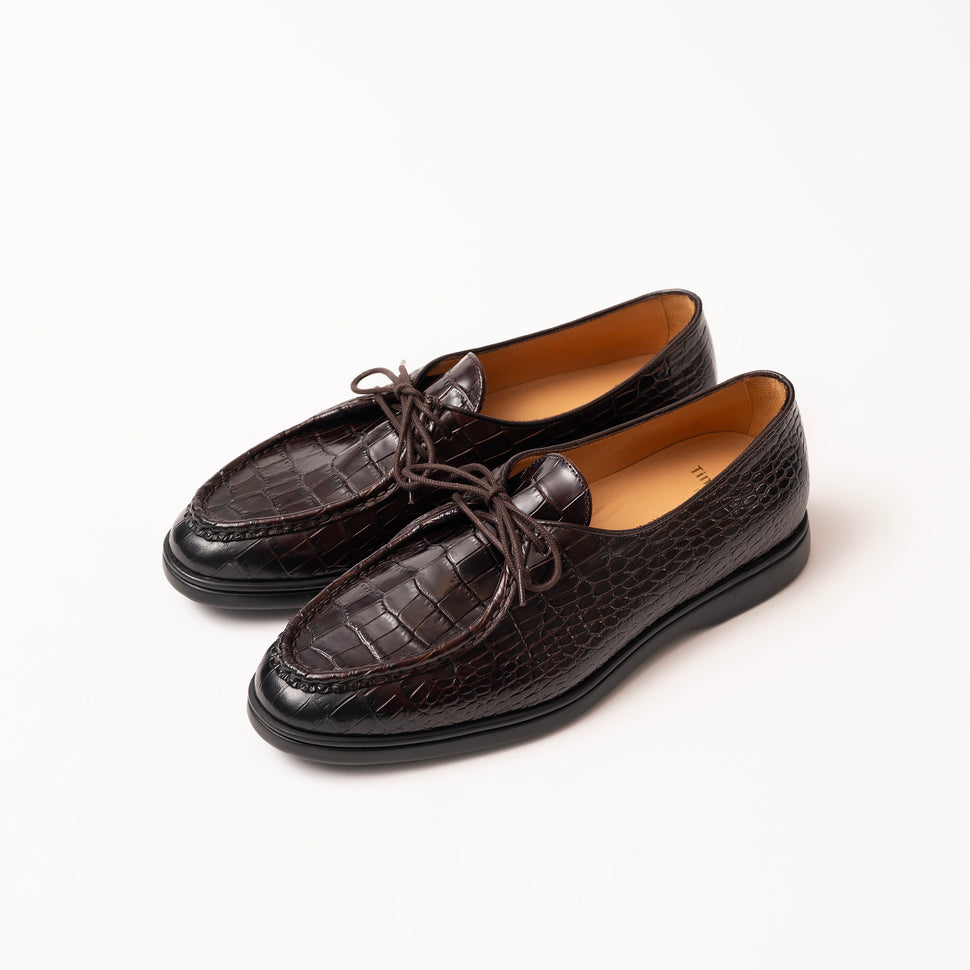 A pair of burgundy brown crocodile-embossed leather loafers by Timothee Paris with matching laces, displayed on a clean white background.
