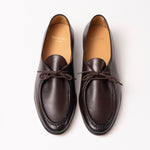 A pair of dark brown leather loafers with  laces, shown from a top-down view on a clean white background. The brand name 'Timothée PARIS' is visible on the tan insoles.
