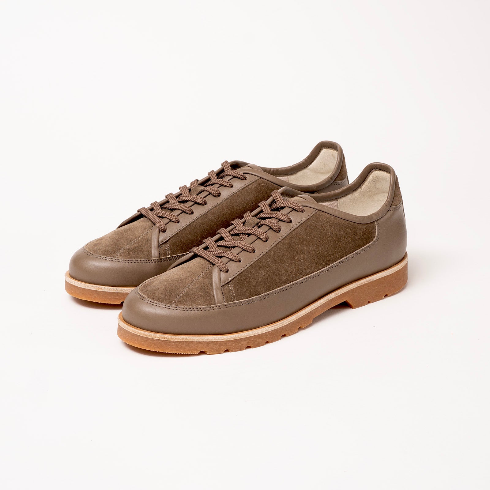Pair of Timothée Paris brown suede shoes Y port with latex sole on a white background