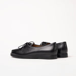 Back view of Beaune lace-up loafers in black pebbled leather by Timothée Paris, highlighting refined texture and natural rubber sole.