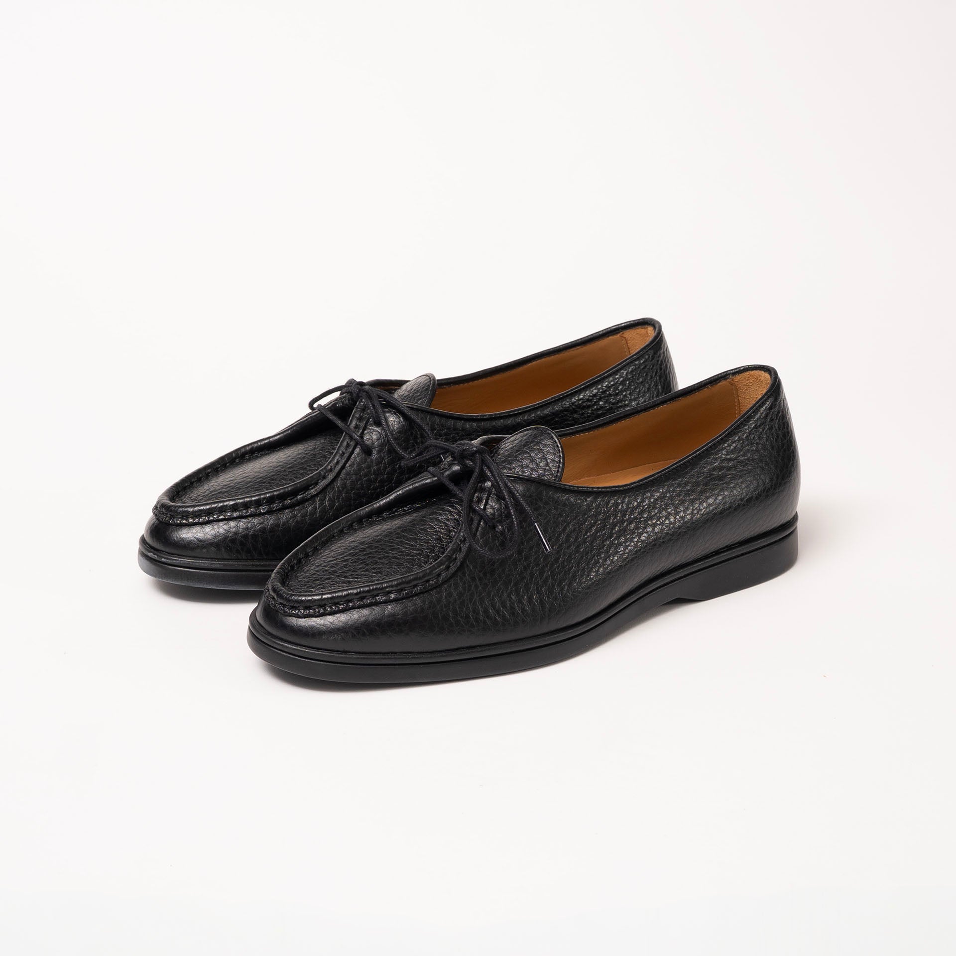 Three-quarter view of Beaune loafers in soft black pebbled leather by Timothée Paris, showcasing its elegant shape and detailed craftsmanship