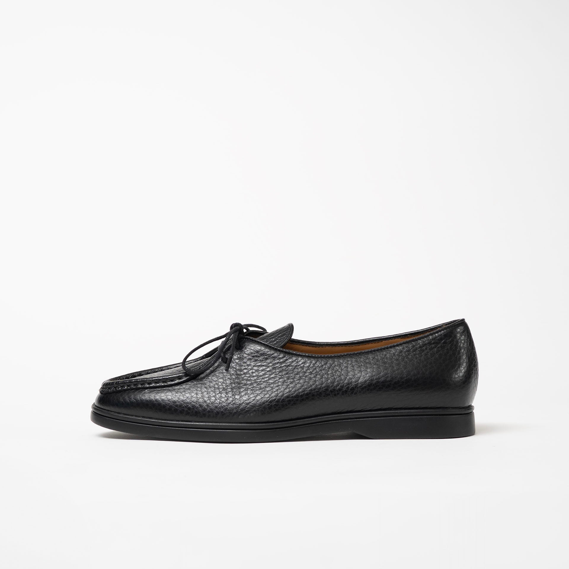 Side view of Beaune loafers in black pebbled leather by Timothée Paris, emphasizing its clean silhouette and subtle refinement