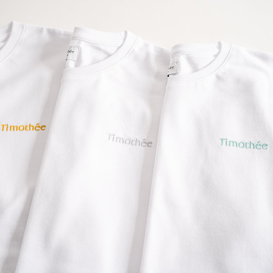 white-short-sleeve-embroidered-timothee-paris-logo-on-chest-oversized-tshirt-gold-silver-green-close-up